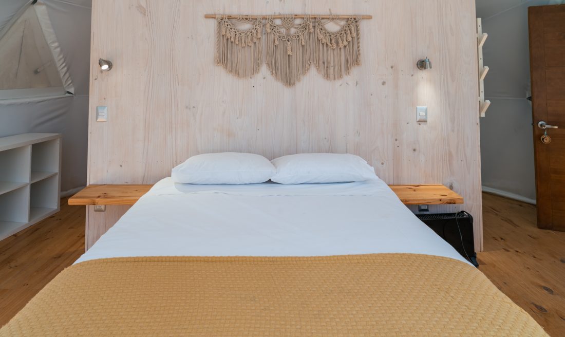 Cama matrimonial con respaldo de madera y macramé