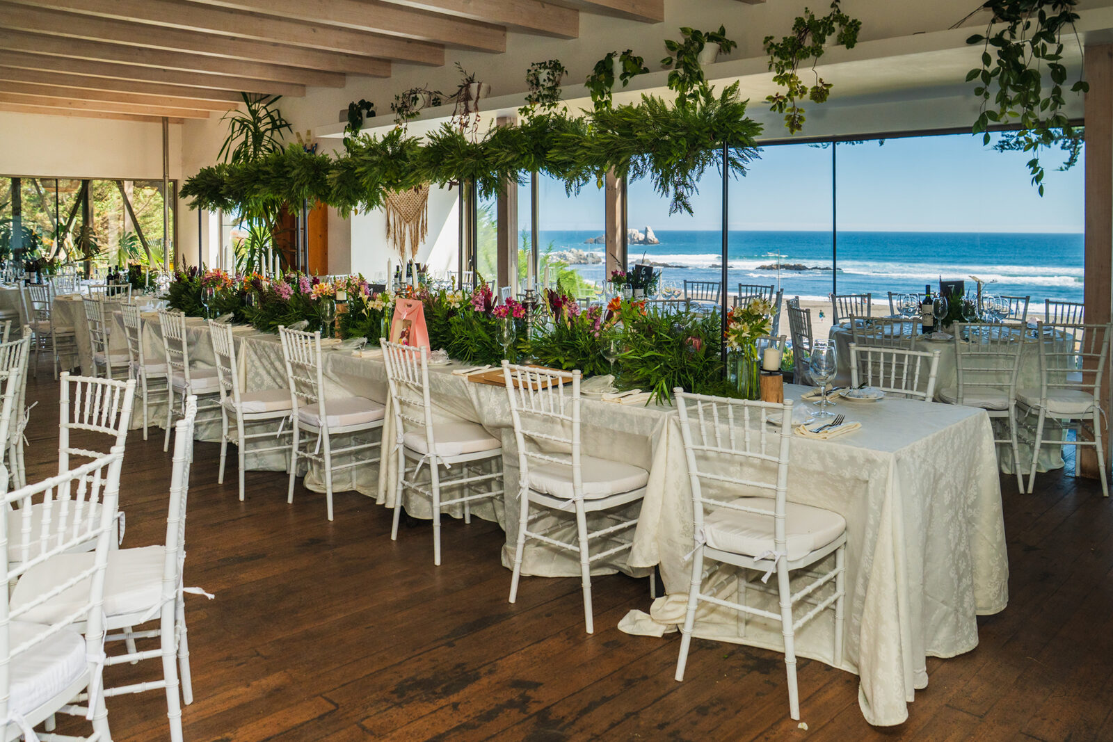 Mesa larga de banquete con guirnalda floral y vista al mar en Matanzas